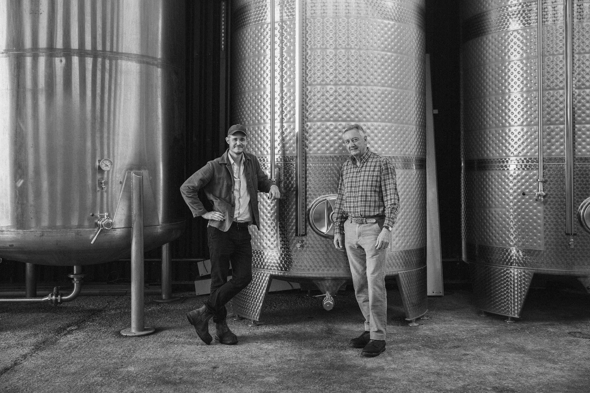 Robert Robinson (cider making generation 5) and his son Angus (generation 6) next to some fermentation tanks at their craft cider works in Little Hereford